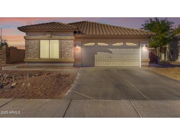 Single-story home with attached garage and landscaped front yard at 15548 N 156Th Ln, Surprise, AZ 85374