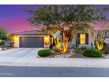 Charming single-story home with desert landscaping, a two-car garage, and warm exterior lighting at 17833 W Verdin Rd, Goodyear, AZ 85338