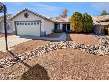 House exterior showcasing a well-maintained front yard and a two-car garage at 18206 N 86Th Ln, Peoria, AZ 85382