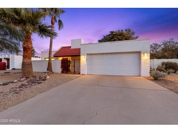 Inviting desert home exterior with a two-car garage and nicely landscaped front yard at 530 E Calavar Rd, Phoenix, AZ 85022