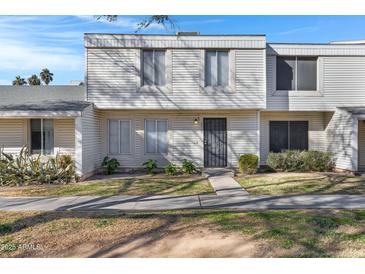 Two-story condo with light-colored siding, a walkway, and landscaping at 6415 S El Camino Dr, Tempe, AZ 85283