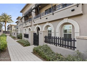 Front view of a modern townhouse with a gated entry and paved walkway at 6565 E Thomas Rd # 1141, Scottsdale, AZ 85251