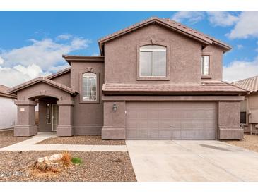 Two-story house with a brown exterior, attached garage, and landscaping at 8802 E University Dr # 66, Mesa, AZ 85207