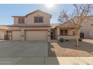 Two-story house with a three-car garage and desert landscaping at 10325 W Windsor Ave, Avondale, AZ 85392