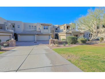 Front view of a modern condo with two-car garage and landscaped lawn at 14850 E Grandview Dr # 138, Fountain Hills, AZ 85268