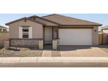 Charming single-story home featuring a two car garage, block wall, and low maintenance gravel yard at 17761 W Elm St, Goodyear, AZ 85395