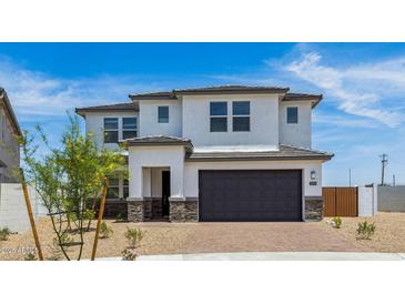 Two story home featuring a two-car garage, desert landscaping, and neutral-colored paint at 2316 W Moody Trl, Phoenix, AZ 85041