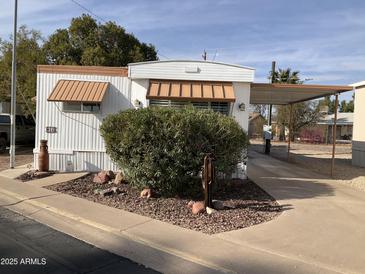 Single-wide manufactured home with carport and landscaping at 2460 E Main St # N12, Mesa, AZ 85213