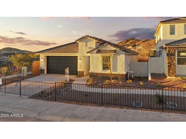 Inviting single-story home with a two-car garage, xeriscaped front yard, and mountain views at 27256 N 74Th Ln, Peoria, AZ 85383