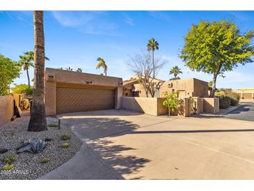 Desert landscaping surrounds this beautiful home with a large garage and gated entry at 4450 E Camelback Rd # 4, Phoenix, AZ 85018