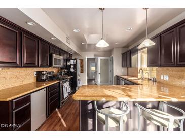 Modern kitchen with dark wood cabinets and granite counters at 102 W El Caminito Dr, Phoenix, AZ 85021