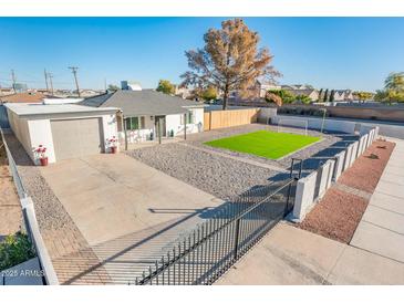 Property with artificial turf, block wall, and gated entry at 10902 W Flanagan St, Avondale, AZ 85323