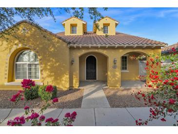 Beautiful two-story home with a charming yellow exterior and landscaping at 1161 S Storment Ln, Gilbert, AZ 85296