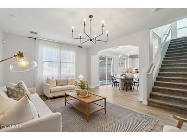 Bright and airy living room featuring modern lighting, plush seating, and an open floor plan at 18260 W Bridger St, Surprise, AZ 85388