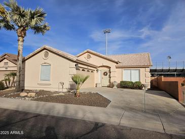 Tan house with a two-car garage and desert landscaping at 18803 N 16Th Pl, Phoenix, AZ 85024