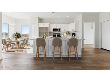 Modern kitchen with island, stainless steel appliances, and white cabinets at 20235 W Highland Ave, Litchfield Park, AZ 85340