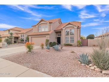 Two-story house with a tan exterior, landscaped yard, and two-car garage at 4028 N Ranier --, Mesa, AZ 85215