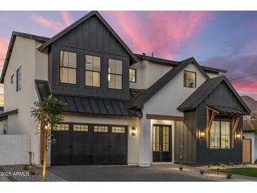 Striking two-story home boasts modern farmhouse design with black trim and a three-car garage at 4420 E Glenrosa Ave, Phoenix, AZ 85018