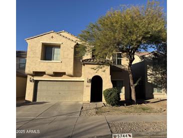 Two-story house with attached garage and mature tree in front at 5744 W Siesta Way, Laveen, AZ 85339