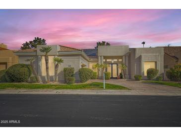 Beautiful single-story home featuring a well-manicured lawn, desert landscaping and a welcoming entrance at 8334 E Jenan Dr, Scottsdale, AZ 85260