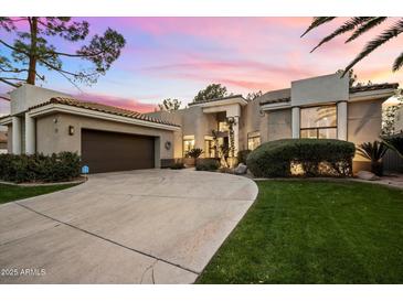 Stunning curb appeal, this home features a large driveway and lush landscaping at 11748 N 80Th Pl, Scottsdale, AZ 85260