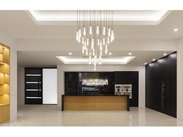 Modern kitchen features sleek black cabinetry, wood island, and striking chandelier lighting at 11612 N 86Th St, Scottsdale, AZ 85260