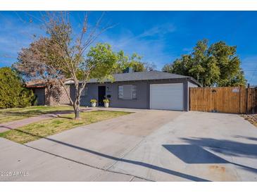 Cute bungalow with gray exterior, white garage door, and a brick walkway at 12023 N 113Th Ave, Youngtown, AZ 85363