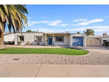 Charming single-story home with a well-manicured lawn and blue garage door at 1637 N Bridalwreath St, Tempe, AZ 85288