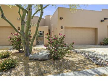 Desert landscape accents this contemporary home's exterior, featuring a private gated entry and two-car garage at 17025 E La Montana Dr # 130, Fountain Hills, AZ 85268