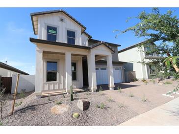 Attractive two-story home showcasing a welcoming front porch with sturdy columns and a well-maintained front yard at 1932 W Rowel Rd, Phoenix, AZ 85085