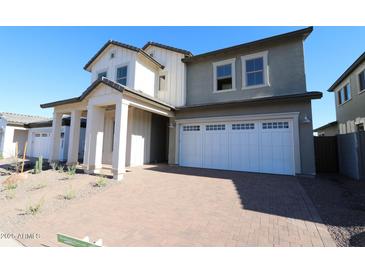 Charming two-story home featuring a two-car garage and a welcoming covered entryway with substantial pillars at 1932 W Rowel Rd, Phoenix, AZ 85085