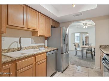 Spacious kitchen, granite counters, stainless steel appliances, and view to dining area at 3825 E Camelback Rd # 239, Phoenix, AZ 85018