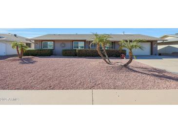 Single story home with desert landscaping and a two-car garage at 9821 W Cedar Dr, Sun City, AZ 85351