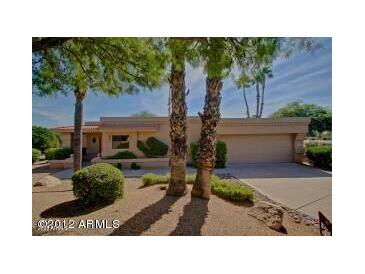 Tan single story home with mature landscaping and a two car garage at 25609 N Forest Rd # 20, Rio Verde, AZ 85263