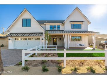 Two-story farmhouse features white siding, a metal roof, and a white picket fence at 3427 E Campbell Ave, Phoenix, AZ 85018