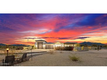 Stunning desert home exterior at sunset, featuring a large garage and manicured landscaping at 34709 N 48Th St, Cave Creek, AZ 85331