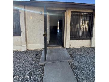 Front exterior view of a single story home with open door at 3646 N 69Th Ave # 55, Phoenix, AZ 85033