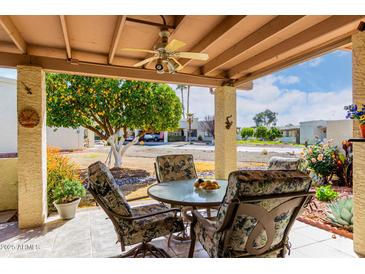 Covered patio with seating area, lemon tree, and view of the community at 7911 E Desert Trl, Mesa, AZ 85208