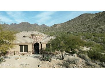 One-story home with stone accents and a tile roof, nestled in a mountain setting at 14065 N 111Th Pl, Scottsdale, AZ 85255