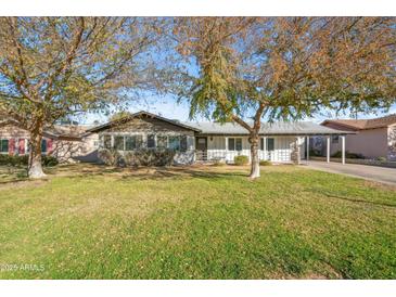 Charming single-story home featuring a well-maintained front yard and mature trees at 1632 E Maryland Ave, Phoenix, AZ 85016