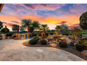 Outdoor kitchen, water feature, and expansive patio create a relaxing backyard retreat at 26702 W Sierra Pinta Dr, Buckeye, AZ 85396