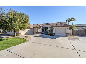 Single-story home with a two-car garage and lush landscaping at 3121 E Hackamore St, Mesa, AZ 85213