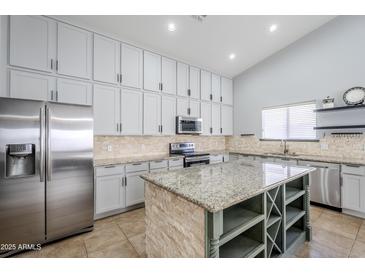 Modern kitchen with stainless steel appliances and granite island at 3121 E Hackamore St, Mesa, AZ 85213