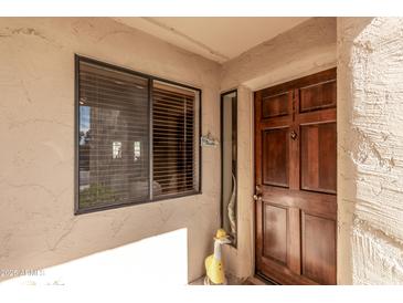 Inviting front door and window adorned with a charming duck, creating a warm welcome to the home at 9270 E Mission Ln # 111, Scottsdale, AZ 85258