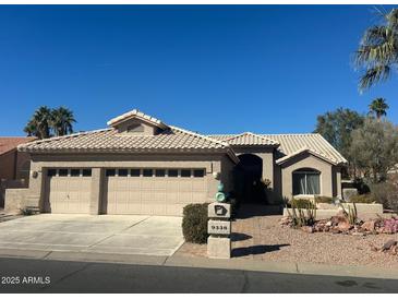 Single-story home with three-car garage and desert landscaping at 9338 E Cherrywood Dr, Sun Lakes, AZ 85248