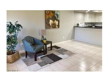 Bright living room features tile floors and a comfy chair at 1432 W Emerald Ave # 51, Mesa, AZ 85202