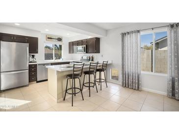 Modern kitchen with stainless steel appliances and an island with seating at 1437 W Ross Ave, Phoenix, AZ 85027