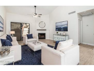 Bright living room with vaulted ceilings, fireplace, and sliding glass door to patio at 1718 S Longmore -- # 52, Mesa, AZ 85202