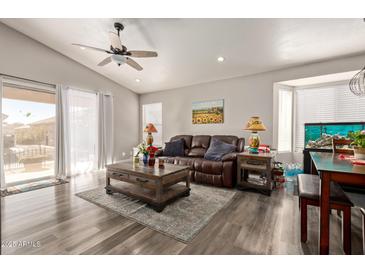 Spacious living room with hardwood floors, a large leather couch, and a ceiling fan at 1823 E Riviera Dr, Chandler, AZ 85249