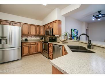 Kitchen with wood cabinets, stainless steel appliances, and granite countertops at 18619 N 136Th Dr, Sun City West, AZ 85375